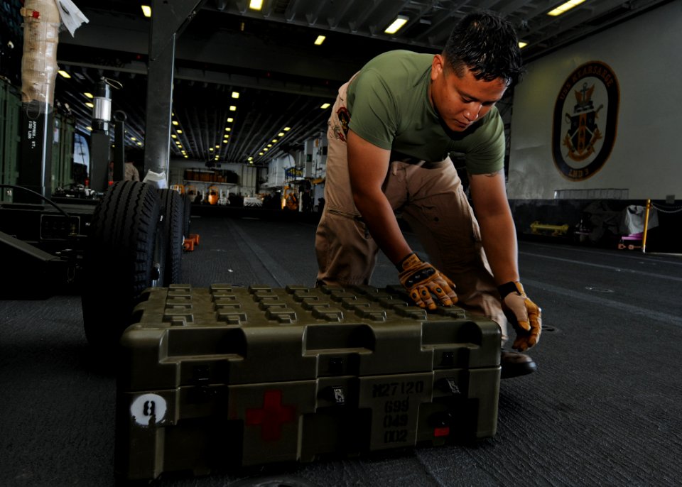 US Navy 100708-N-2908M-013 Hospital Corpsman 1st Class Mark Ligsay loads medical supplies in a quadcon for safe storage aboard USS Kearsarge (LHD 3)