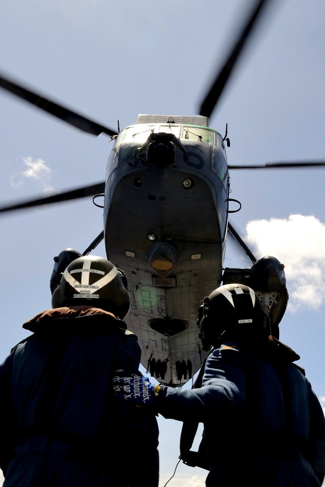 US Navy 100709-O-0000S-003 Cpl. Dale Sinclair, left, and Cpl. Alex Noel stand by to recover a CH-124 Sea King helicopter aboard the Canadian Navy estroyer (HMCS) Algonquin (DDG 283)