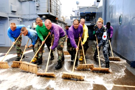 US Navy 100710-N-6477M-517 Royal Australian Navy Dental Assistant Seaman Christie Woodleigh assists Sailors during a scrub exercise while touring USS Cleveland (LPD 7)