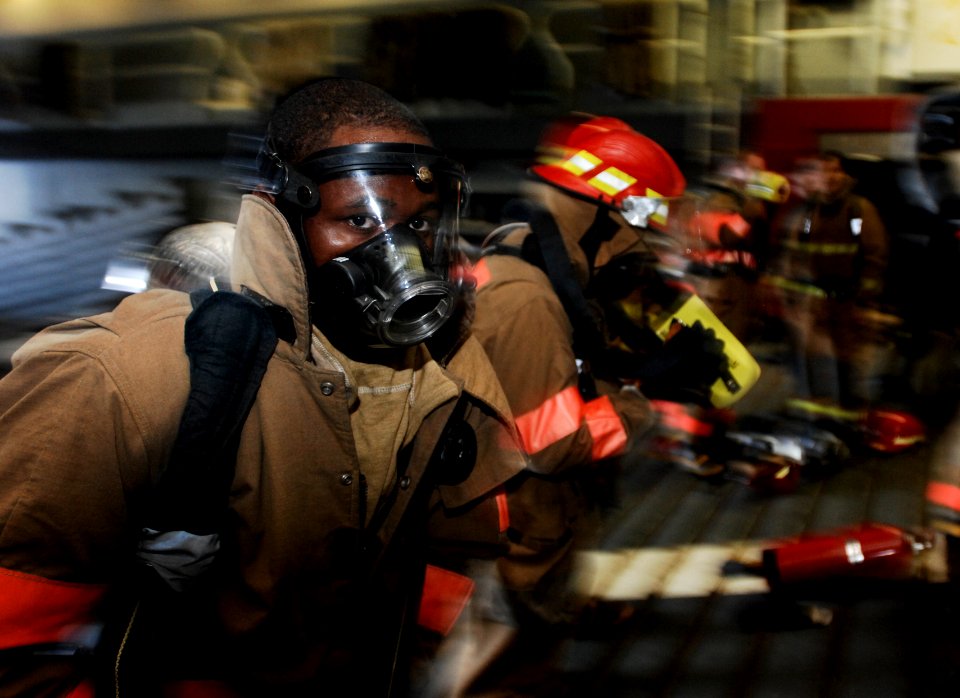 US Navy 100709-N-6477M-100 Sailors don their firefighting ensembles in preparation for combating fires during a main space fire drill aboard USS Cleveland (LPD 7)