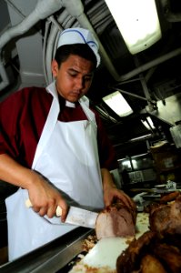 US Navy 100710-N-7191M-012 Culinary Specialist Seaman Apprentice Marco Valdez slices roast pork in the aft galley aboard USS George Washington (CVN 73) photo