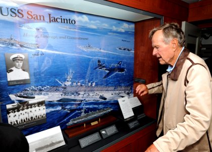 US Navy 100715-N-3885H-006 Former President George H.W. Bush looks at a display of his former ship, the aircraft carrier USS San Jacinto (CVL 30), in the tribute room of the aircraft carrier that bears his name, USS George H.W
