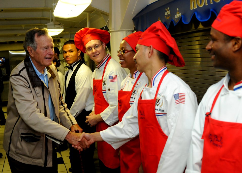 US Navy 100715-N-8689C-126 Former President George H.W. Bush speaks to Sailors after breakfast in the Chief's Mess aboard the aircraft carrier that bears his name, USS George H.W. Bush (CVN 77)