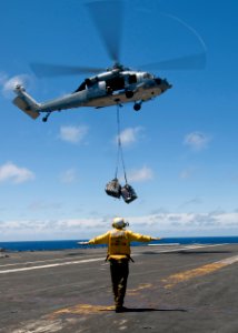 US Navy 100715-N-4830B-049 Aviation Boatswain's Mate (Handling) 3rd Class Bryan Rice, from Linwood, Wash., signals to the pilot of an MH-60S Sea Hawk helicopter
