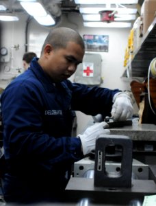 US Navy 100714-N-3852A-178 Machinist's Mate Fireman Ryant Delossantos, from Manila, Philippines, performs calibration of a micrometer tool in the calibration lab aboard the amphibious assault ship USS Wasp (LHD 1)