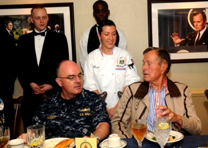 US Navy 100714-N-7908T-034 Former President George H.W. Bush speaks with Culinary Specialist 2nd Class Lessa M. Zilempe, assigned to the supply department aboard the aircraft carrier USS George H.W. Bush (CVN 77) photo