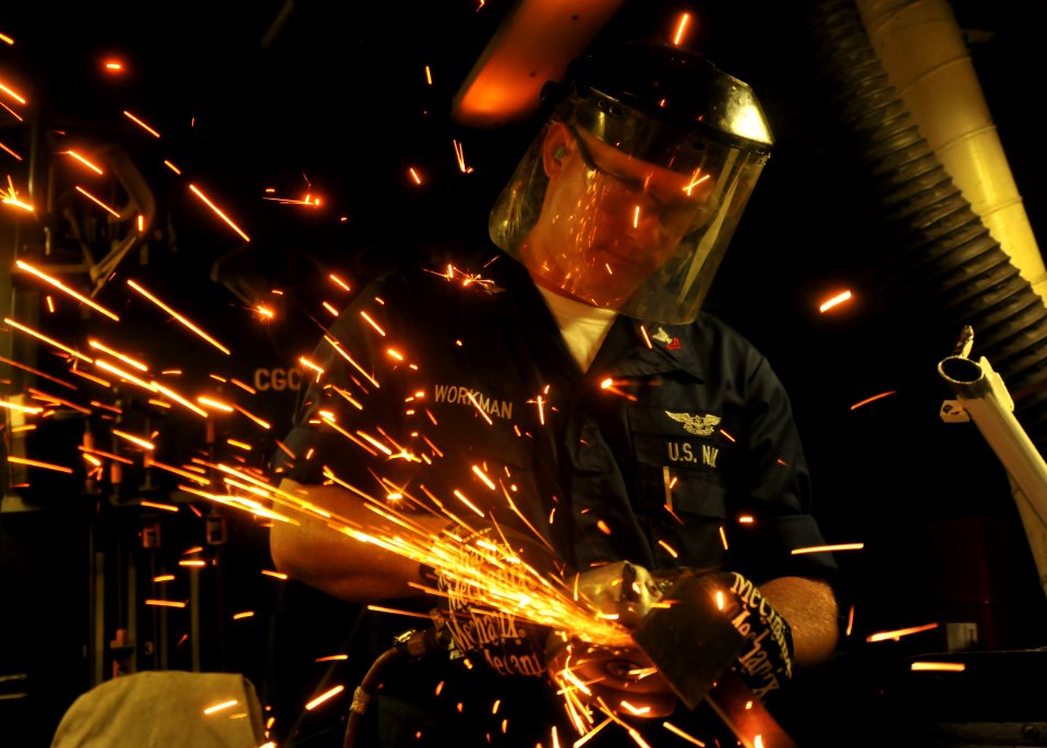 US Navy 100715-N-0569K-026 Aviation Structural Mechanic 2nd Class Timothy J. Workman grinds steel used for aircraft support equipment repairs in the jet shop aboard the aircraft carrier USS Enterprise (CVN 65)