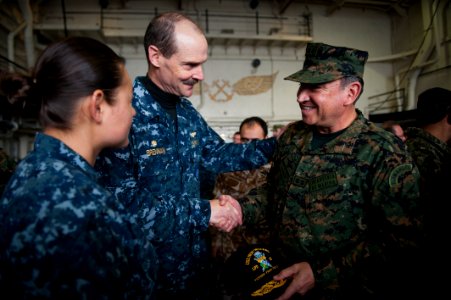 US Navy 100719-N-5319A-428 Capt. Peter Brennan, commodore of Amphibious Squadron (PHIBRON) 5, greets Rear Adm. Luis Ramos, the Peruvian marine commandant, in the hanger bay of the amphibious transport dock ship USS New Orleans