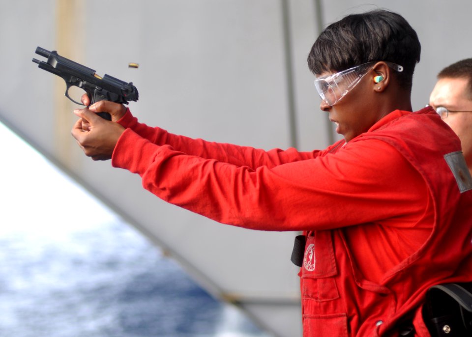 US Navy 100717-N-2013O-022 Aviation Ordnanceman Airman Amber Samuel fires an M-9 pistol during a small-arms live-fire exercise
