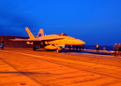 US Navy 100715-N-8913A-011 Sailors stand by as an F-A-18 Hornet prepares to launch from USS George H.W. Bush (CVN 77)