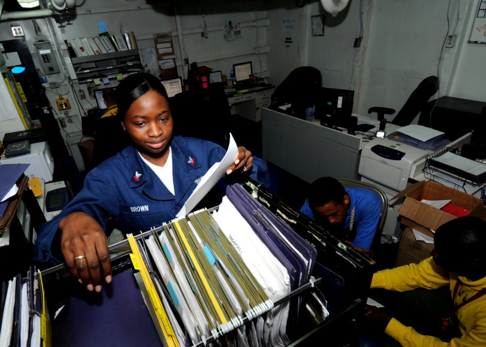 US Navy 100716-N-7191M-009 Aviation Boatswain's Mate (Handling) 2nd Class Karlian Brown, from Clarendon, Jamaica, files training information in the V-1 Division office aboard the aircraft carrier USS George Washington (CVN 73)
