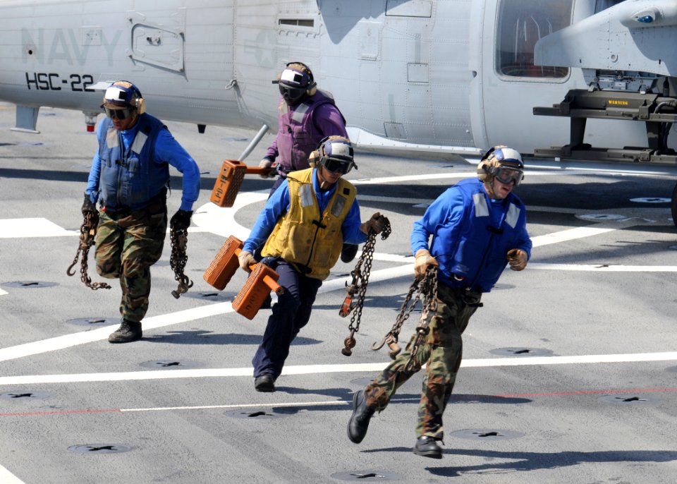 US Navy 100720-N-3154P-017 Sailors remove the chocks and chains from an MH-60S Sea Hawk helicopter assigned to Helicopter Sea Combat Squadron (HSC) 22 aboard the amphibious transport dock ship USS Ponce (LPD 15)