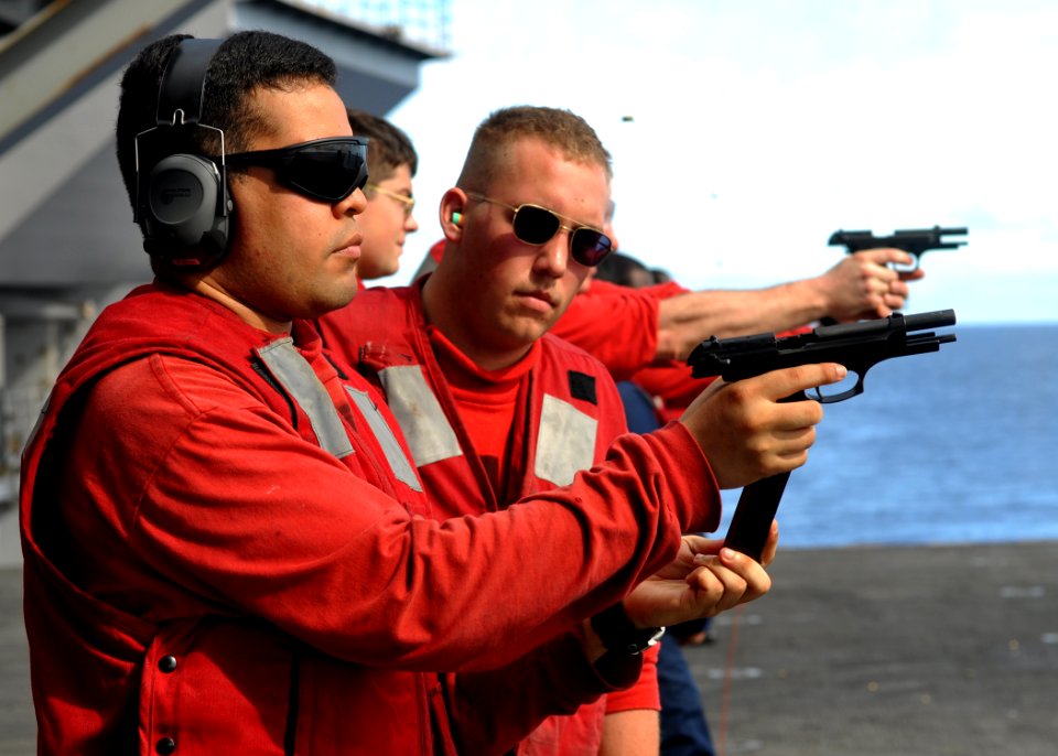 US Navy 100717-N-2013O-190 Gunner's Mate 1st Class Jose Sanchez reloads an M-9 pistol during a small-arms live-fire exercise