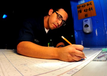 US Navy 100721-N-0569K-047 Operations Specialist Seaman Alcides J. Fuentes plots the position of USS Enterprise (CVN 65)