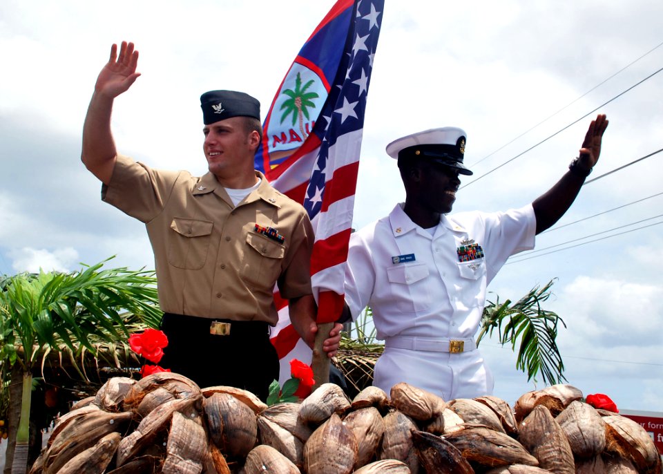 US Navy 100721-N-1722W-257 Religious Programs Specialist 3rd Class Mitchell Moore and Chief Boatswain's Mate Kelton Ringo both assigned to the submarine tender USS Frank Cable (AS 40) waves as they ride the float