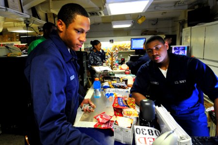 US Navy 100721-N-2953W-383 Ship's Serviceman Seaman Recruit Preston Hornes helps a customer in the ship's store aboard USS Carl Vinson (CVN 70)