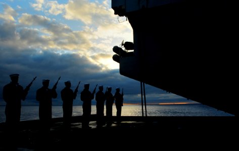 US Navy 100721-N-3595W-007 Sailors present arms during a sunrise burial at sea aboard USS Dwight D. Eisenhower (CVN 69) photo