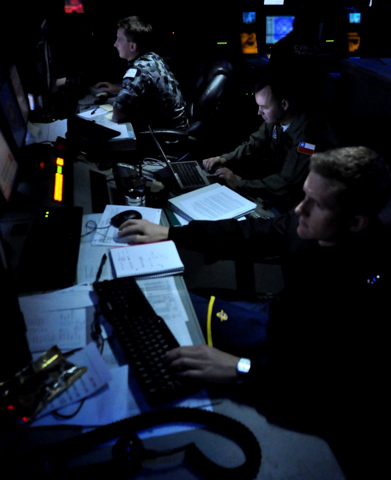 US Navy 100719-N-7042V-107 Royal Australian Navy Leading Seaman Livingston Harrison, foreground, U.S. Navy Lt. j.g. Joe Spence and Columbian navy Lt. Cmdr. Anibal Limbo stand watch in Sea Combat Control a