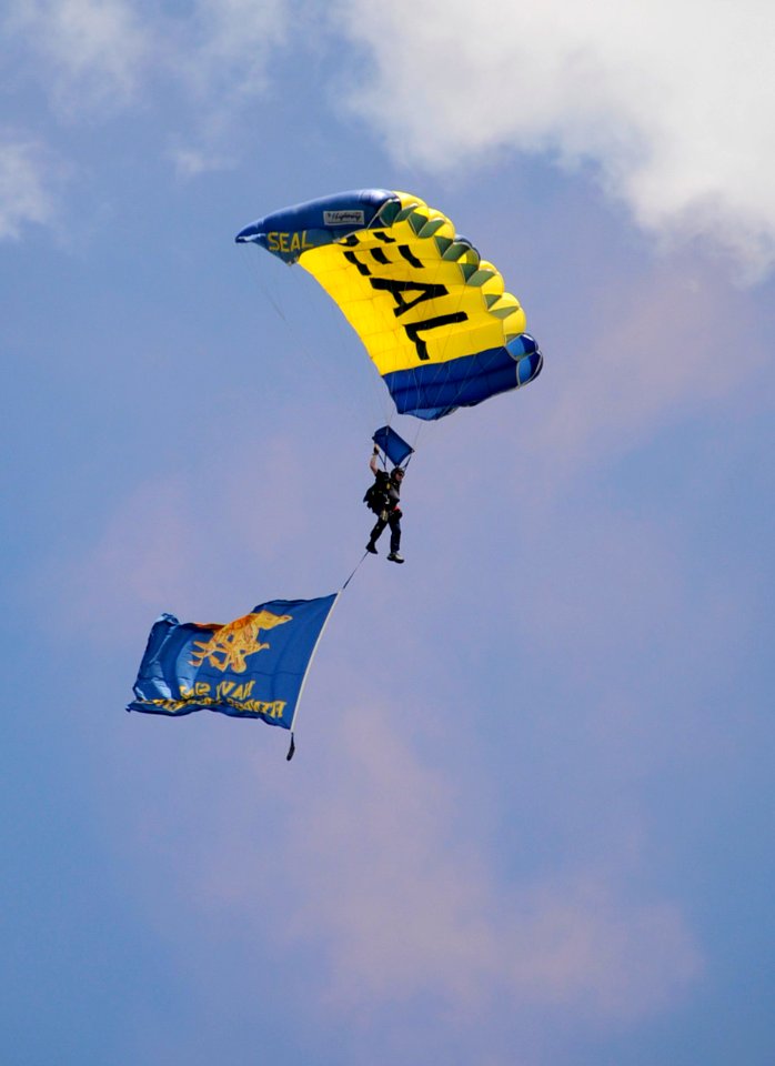 US Navy 100720-N-5366K-118 Chief Special Warfare Operator (SEAL) Justin Gauny flies with a Navy SEAL trident flag during the opening ceremony of a St. Paul Saints baseball game at Midway Stadium