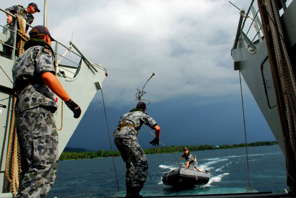 US Navy 100720-N-4044H-477 An Australian Royal Navy Sailor throws a line to Sailors aboard the Australian Royal Navy amphibious ship (HMAS) Labuan (L128)