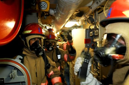 US Navy 100723-N-6477M-034 ailors stand by to enter Main Engine Room 2 during a main space fire drill aboard the amphibious transport dock ship USS Cleveland (LPD 7)
