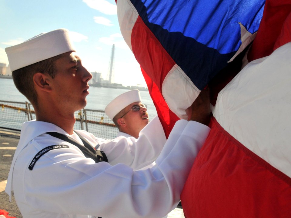 US Navy 100724-N-3283P-036 Seaman Justin Popp prepares to raise the flag during morning colors aboard the guided-missile destroyer USS Russell (DDG 59)