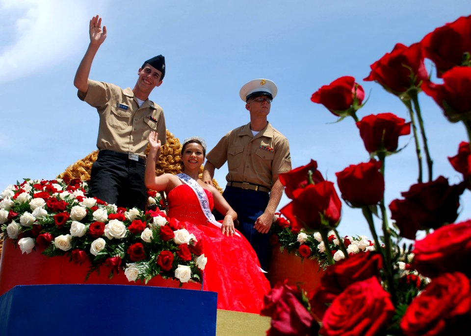 US Navy 100721-N-1722W-192 The village of Piti's Royal Princess RayAna Lujan Rojas, escorted by a Sailor and a Marine, waves as they ride the float during the 66th annual Liberation Day celebration parade