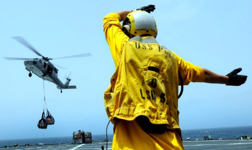 US Navy 100722-N-7948R-040 Boatswain's Mate 3rd Class Thomas OMalia signals the pilot of an MH-60S Sea Hawk helicopter to fly left during a vertical replenishment aboard the amphibious dock landing ship USS Pearl Harbor (LSD 52 photo