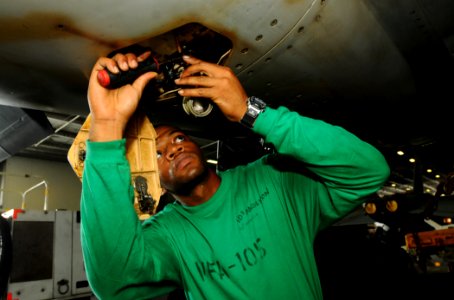 US Navy 100722-N-1092P-077 Aviation Machinist's Mate 3rd Class Adrian Anderson performs a routine maintenance check on an F-A-18E Super Hornet aboard USS Harry S. Truman (CVN 75)