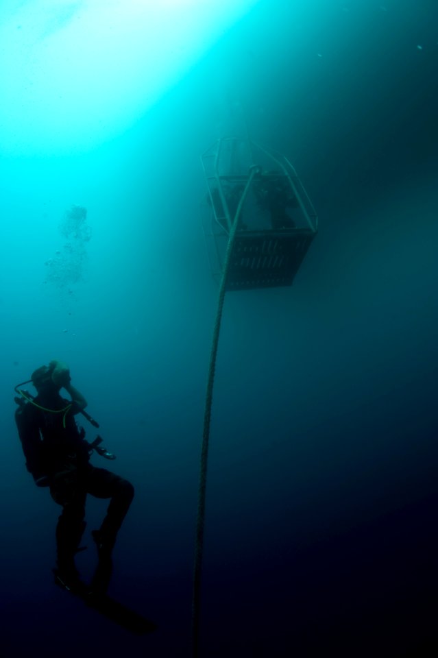 US Navy 100722-N-1134I-095 Navy Diver 2nd Class Steve Vanzant watches fellow divers as they are lowered into the ocean during a salvage recovery exercise