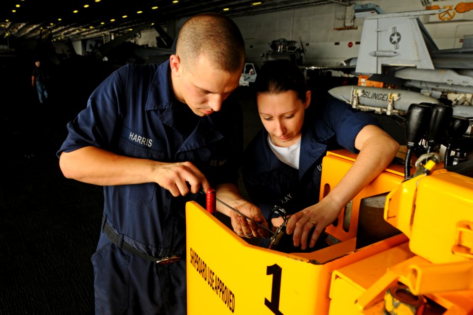 US Navy 100726-N-1092P-088 Aviation Ordnanceman David Harris, from Greenville, N.C., and Electrician's Mate Fireman Cheryl Fendlay, from Salem, Va., repair the potentiometer on a forklift