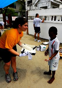 US Navy 100722-N-9643W-702 Lt. j.g. Joan Mulligan, embarked aboard High Speed Vessel Swift (HSV 2), takes a paint tray and roller from a child photo