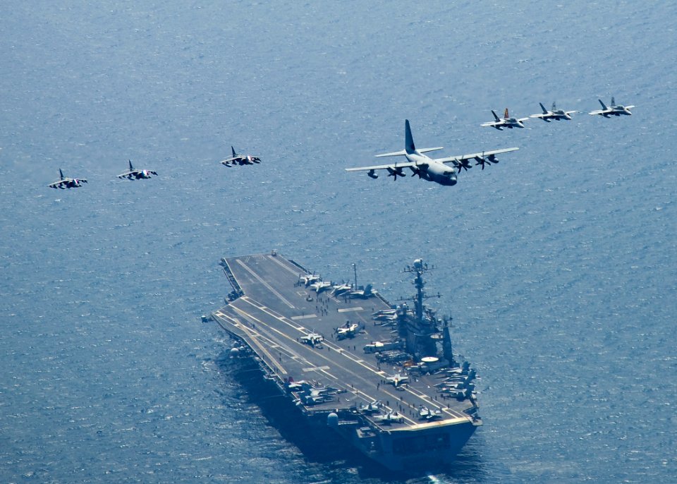 US Navy 100727-N-2013O-063 Marine Corps C-130 Hercules leads a formation of F-A-18C Hornets and A-V-8B Harriers as they fly in formation over USS George Washington (CVN 73)