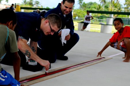 US Navy 100727-N-7280V-398 Information Systems Technician 1st Class Nicholas Delgado, left, and Logistics Specialist 2nd Class Riad Taha paint a basketball court during a community service project for Peleliu Elementary School
