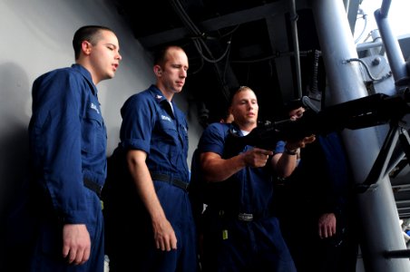 US Navy 100728-N-3852A-693 Aviation Ordnanceman 2nd Class Zach Bernat demonstrates proper handling and safety procedures for the M-240B machine gun before Sailors qualify to operate the weapon