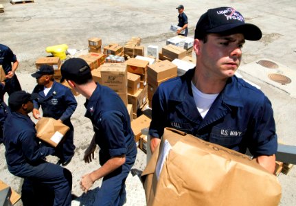US Navy 100728-N-7638K-253 Operations Specialist Seaman Thaddeus Hall, from Myrtle Beach, S.C., passes a box of supplies during an all hands working party aboard the Oliver Hazard Perry-class guided-missile frigate USS Taylor (
