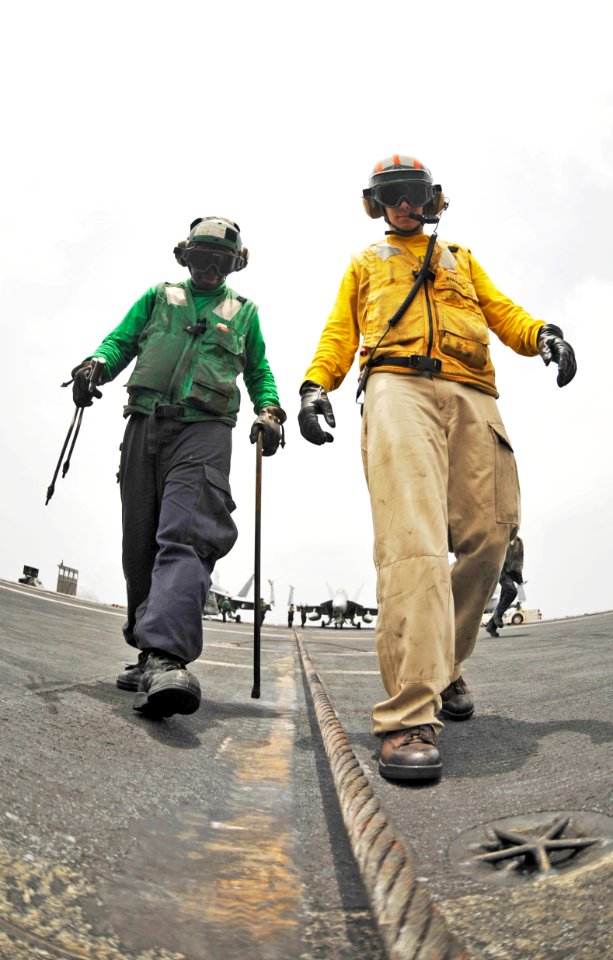 US Navy 100725-N-6003P-189 t. Russ White, right, and Aviation Boatswain's Mate (Handling) Airman Chad David inspect arresting wire three before aircraft land aboard the aircraft carrier USS Harry S. Truman (CVN 75)