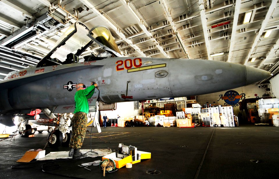 US Navy 100728-N-6003P-127 Sgt. Jason Goedde sands down an F-A-18C Hornet in the hangar bay aboard USS Harry S. Truman (CVN 75)