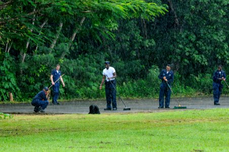 US Navy 100729-N-7478G-076 Sailors assigned to the U.S. 7th Fleet command ship USS Blue Ridge (LCC 19) clean a basketball court in the rain at Angaur Elementary School in support of Pacific Partnership 2010