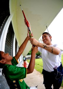 US Navy 100727-N-4031K-329 Information Systems Technician Seaman Bianca Cabral paints with a Palauan child at Ngchesar Elementary School in Koror, Palau