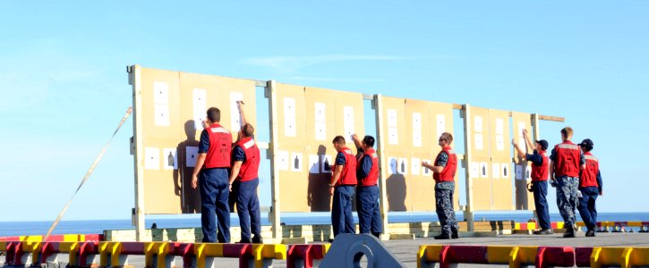 US Navy 100727-N-3852A-089 Line Coaches from the weapons department of the amphibious assault ship USS Wasp (LHD 1) tally shooting scores to determine which Sailors are qualified to operate M-16 rifles