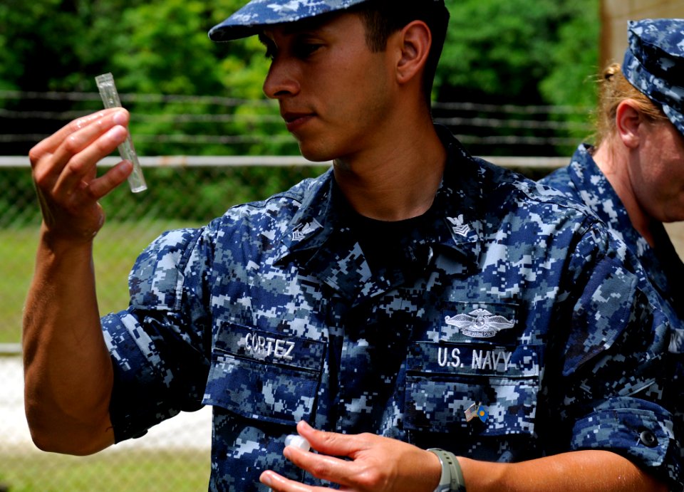 US Navy 100727-N-7280V-401 Hospital Corpsman 1st Class Lee Cortez takes water samples at a local well to determine PH levels