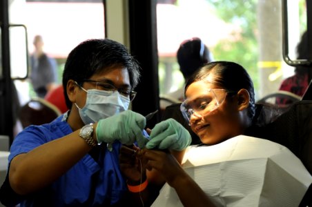 US Navy 100728-N-0864H-092 Hospital Corpsman 1st Class Agnes Banias, assigned to the U.S 7th Fleet command ship USS Blue Ridge (LCC 19), teaches a child how to floss at a Pacific Partnership 2010 free dental clinic