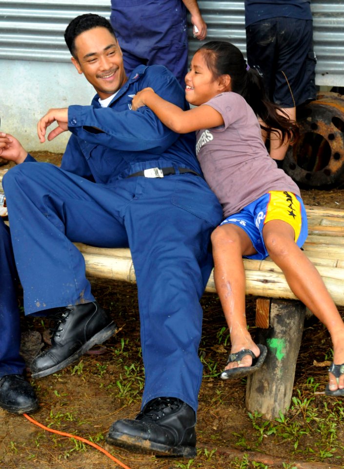 US Navy 100729-N-1675O-313 Aerographer's Mate 1st Class Chi Maxey plays with a Palauan child during a Pacific Partnership community servic