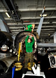 US Navy 100728-N-6003P-128 Sgt. Kyle Selman, bottom, and Cpl. Benjamin Cervantes rivet brackets into the engine space of an F-A-18C Hornet
