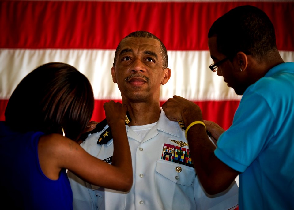 US Navy 100729-N-0807W-023 Family members attach new shoulder boards to Rear Adm. John W. Smith Jr., from Brooklyn, N.Y., during a frocking ceremony at Navy Cyber Forces