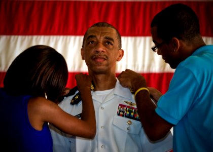 US Navy 100729-N-0807W-023 Family members attach new shoulder boards to Rear Adm. John W. Smith Jr., from Brooklyn, N.Y., during a frocking ceremony at Navy Cyber Forces