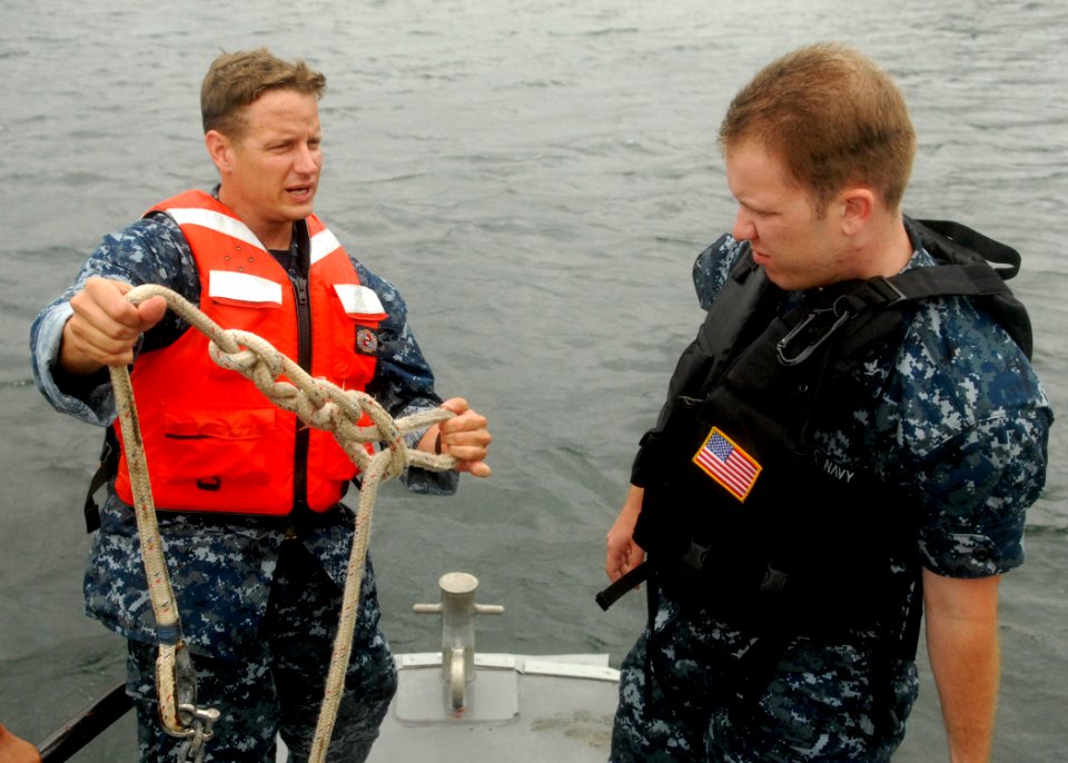 US Navy 100729-N-2218S-037 Chief Boatswain's Mate John Tredway shows Master-at-Arms 3rd Class Hull Rohde how to tie a knot
