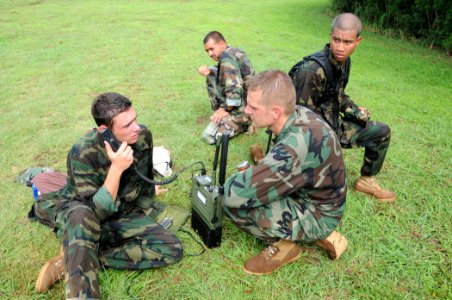 US Navy 100730-N-1906L-008 aster-at-Arms 3rd Class Phillip Channer and other Sailors transmit a message through a multi-band radio they assembled at a communications training station during a Monster Mash exercise at U.S. Naval