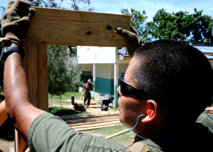 US Navy 100730-N-4153W-539 U.S. Marine Cpl. Otis Peshlakai from Logistical Support Element, embarked aboard the multi-purpose amphibious assault ship USS Iwo Jima (LHD 7), builds an outdoor shelter at a local hospital in Port-d
